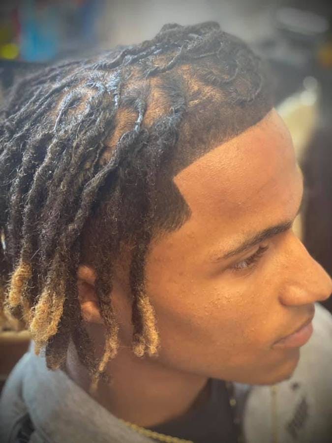 picture of a black man with dreadlocks and blonde highlights 